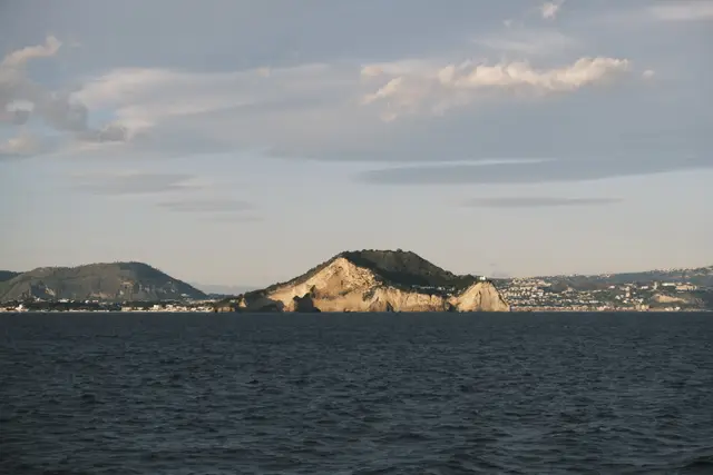 A pale cliffed headland catching late sun across the water.