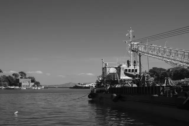 A work boat with a crane moored in Ischia's harbor.