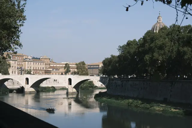 The Tiber and Ponte Mazzini, a small boat, a church dome above the trees.