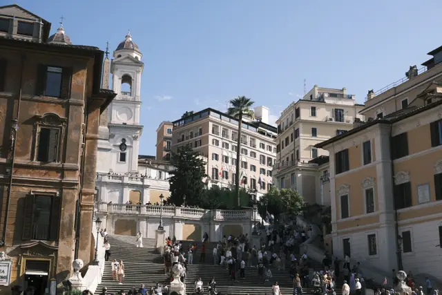 The Spanish Steps crowded with people, Trinità dei Monti at the top.